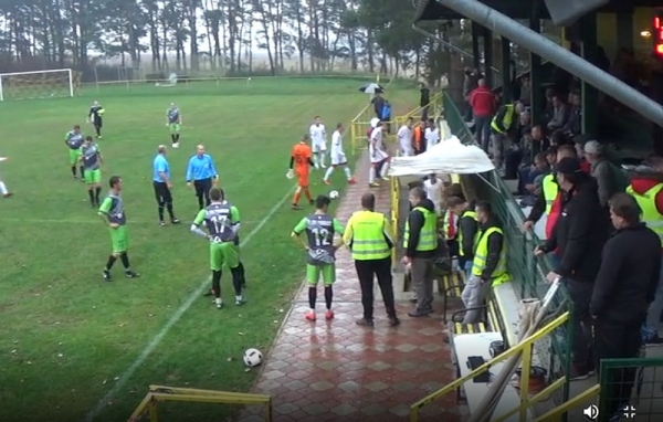 Hráči domáceho mužstva FK Krásnohorské Podhradie slušne čakajú po polčase odchod hosťujúceho mužstva Čičaroviec z plochy ihriska do šatní.